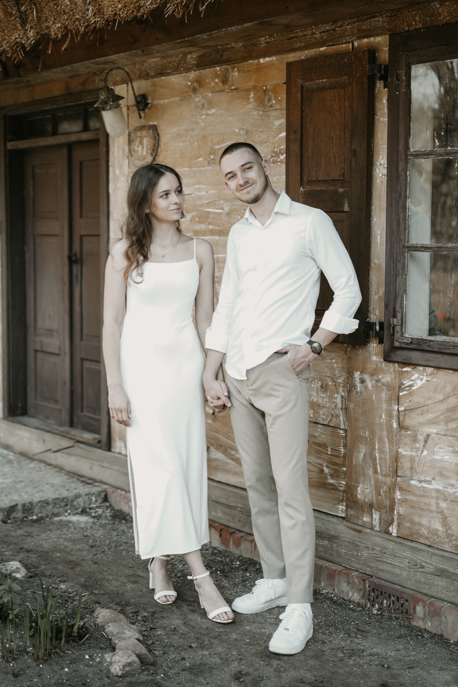 Weronika i Adam stoją przed drewnianym domem